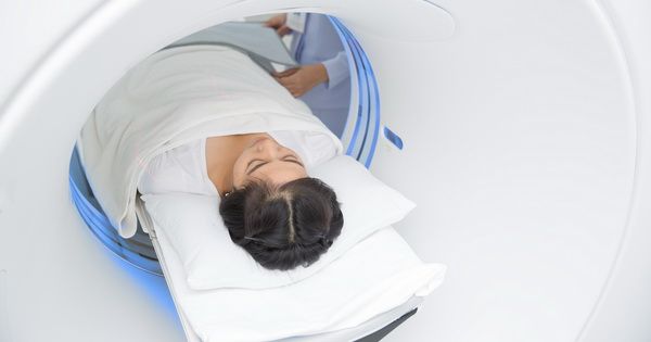 Asian lady sleep on a CT Scan bed and panel control by Radiologic technician